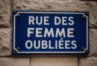 Plaque de nom de rue portant l'inscription "Rue des femmes oubliées"
